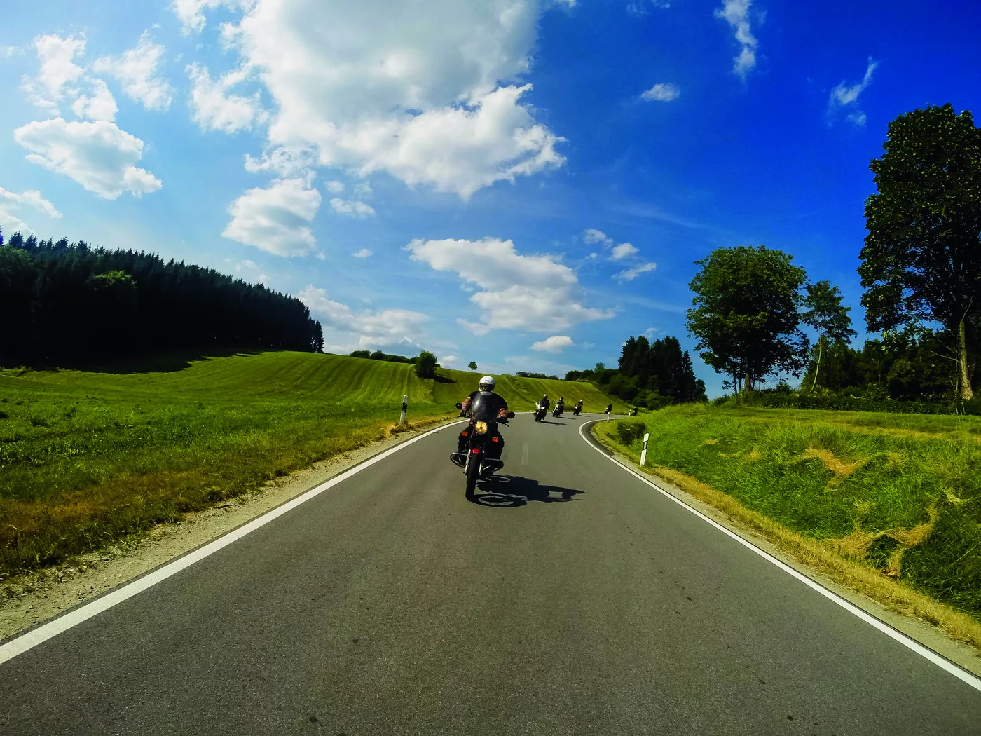 Mehrere Motorräder auf einer weiten Landstraße